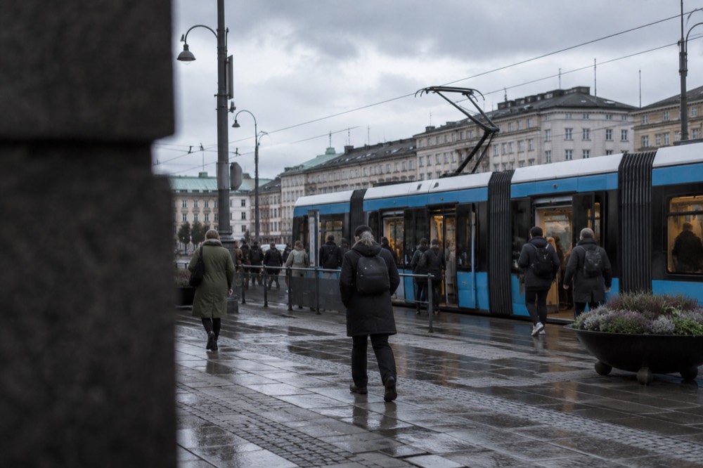 A blue Gothenburg tram at a street stop in the city centre on a grey day
