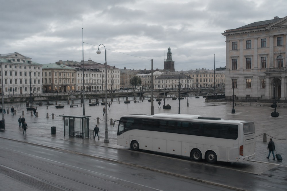 An airport coach parked outside Landvetter Airport terminal in Gothenburg, Sweden, under a grey sky