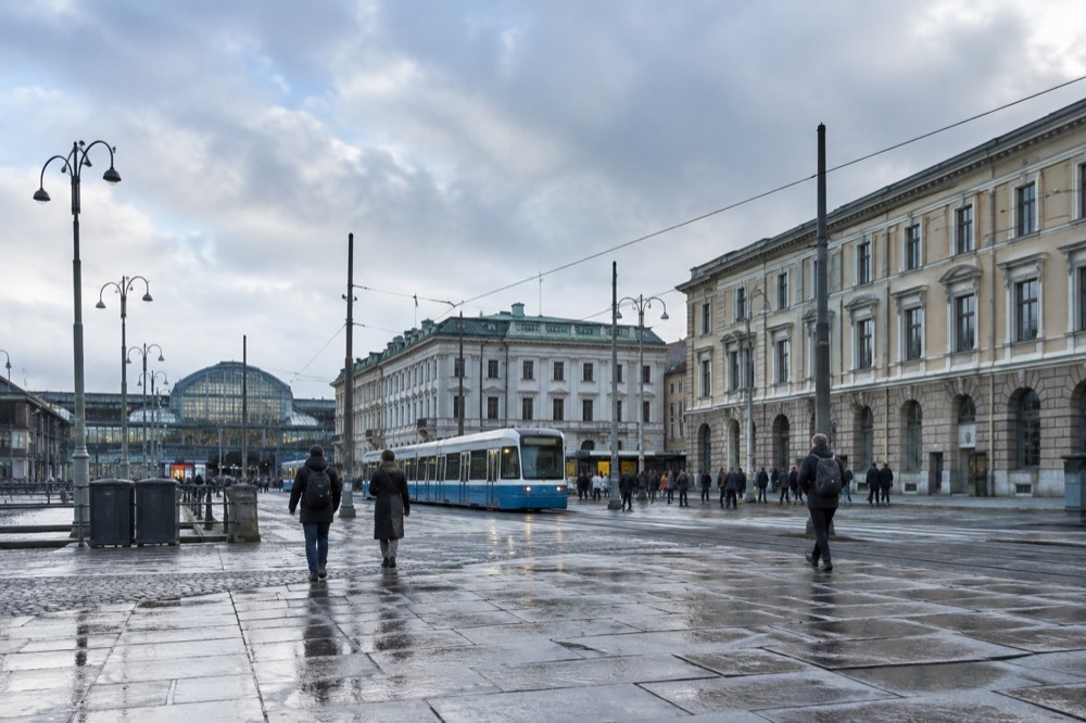 Trams and pedestrians outside Gothenburg Centralstation on a bright morning