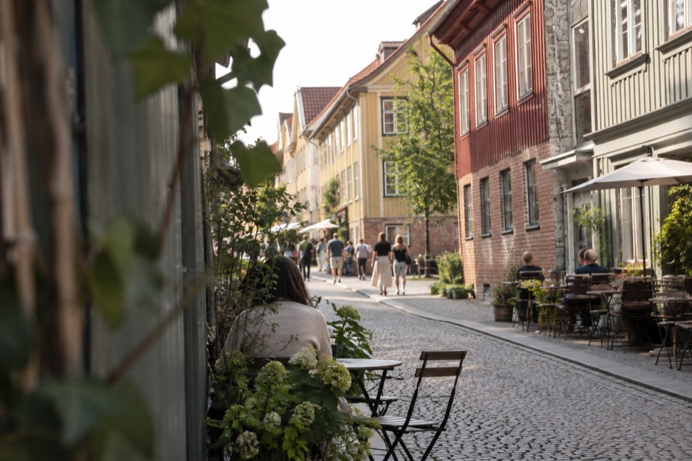 Wooden landshövdingehus houses and cafe tables on a cobbled street in Haga, Gothenburg