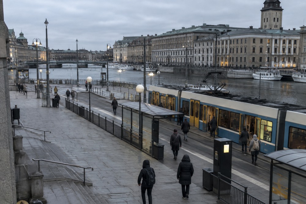 A tram stop ticket machine beside a Gothenburg tram platform in evening light