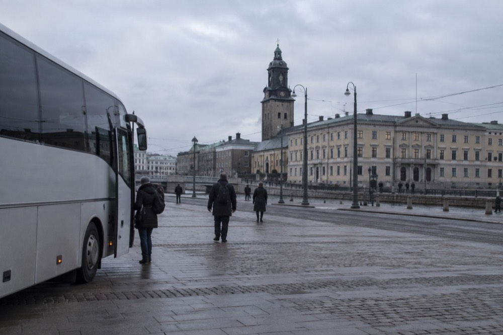 A coach parked outside the terminal building at Gothenburg Landvetter Airport under a grey sky