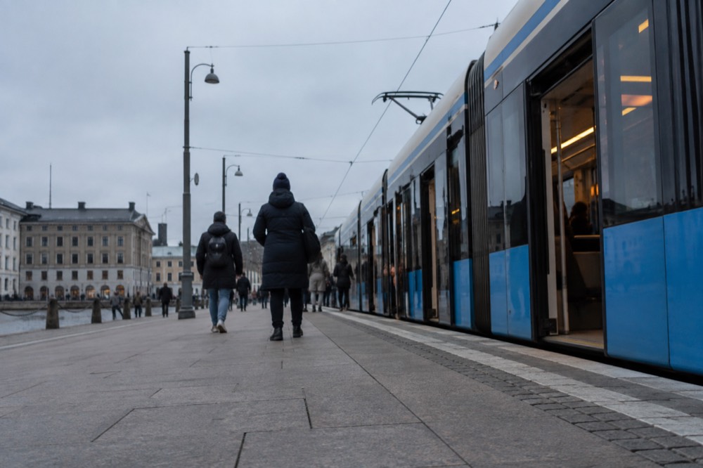A low-floor Gothenburg tram at a city centre stop with level boarding from the platform