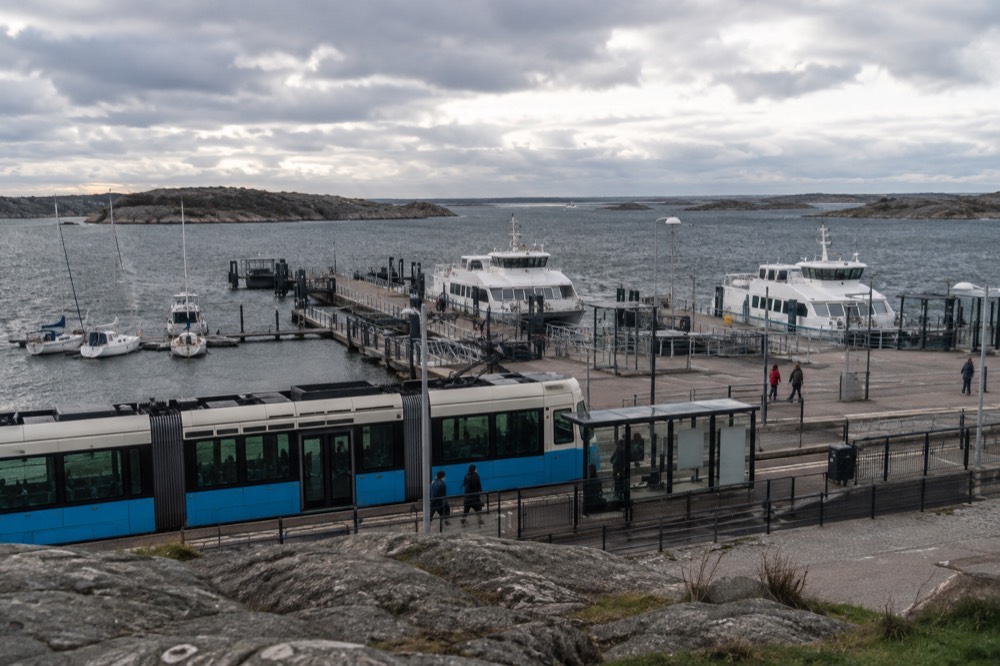 A tram at the Saltholmen terminus in Gothenburg, with the archipelago ferry jetty and open water behind it under a grey sky