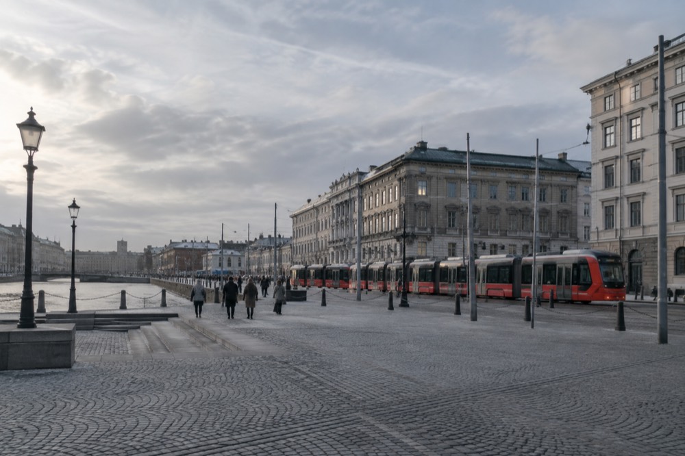 Red trams passing through a Gothenburg street with stone buildings under a grey sky