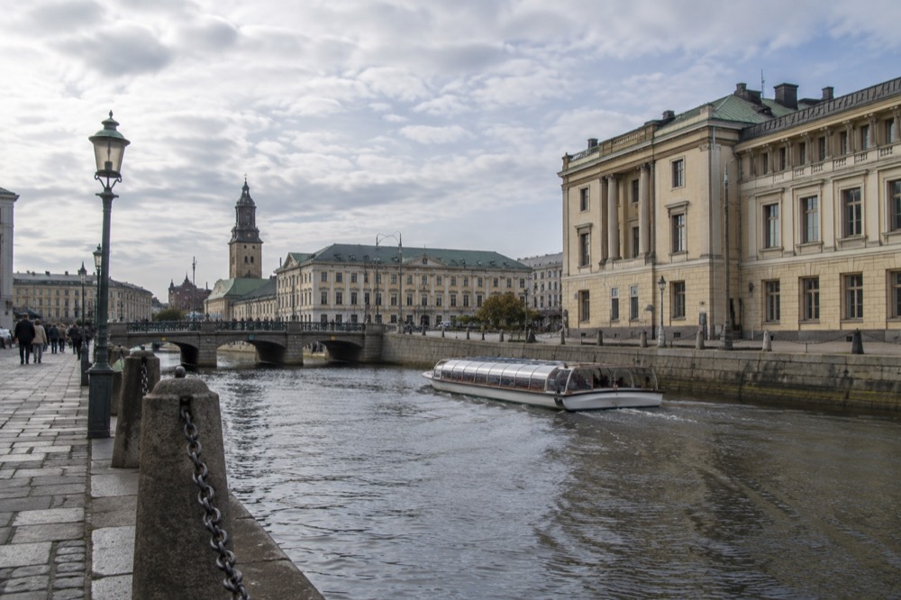 Gothenburg's canal in soft morning light with a sightseeing boat passing old stone buildings