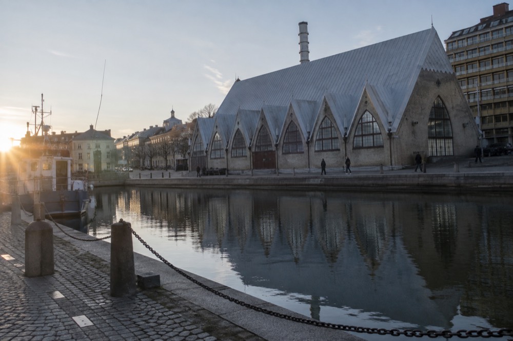 Wooden fish market hall building with a roof shaped like a church nave, seen from a Gothenburg canal-side street