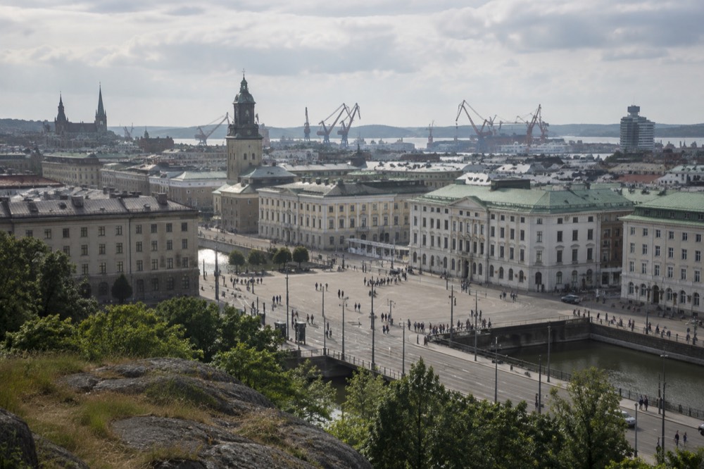 View from a hilltop rampart over Gothenburg rooftops, church towers and harbour cranes under a wide sky
