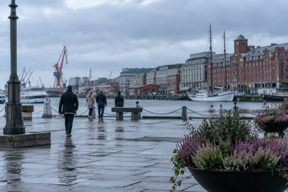 Red brick warehouses and masts along the Göta älv river in central Gothenburg under a grey sky