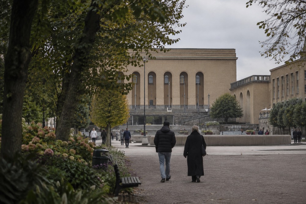 A tree-lined park path near Avenyn with flowerbeds and people strolling