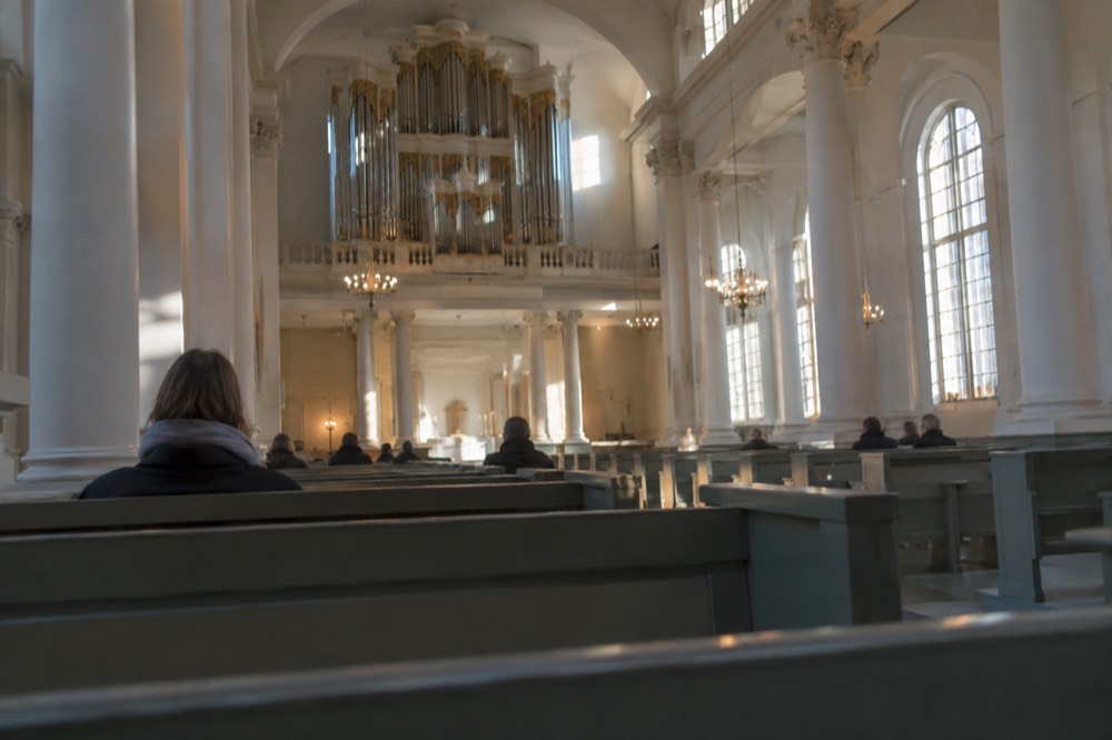 The bright columned interior of Gothenburg Cathedral with a tall organ case above the gallery