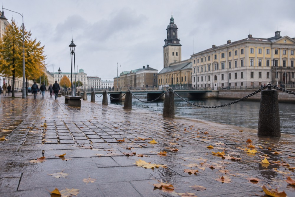 Wet cobbles and stone townhouses along the moat canal in Gothenburg after autumn rain