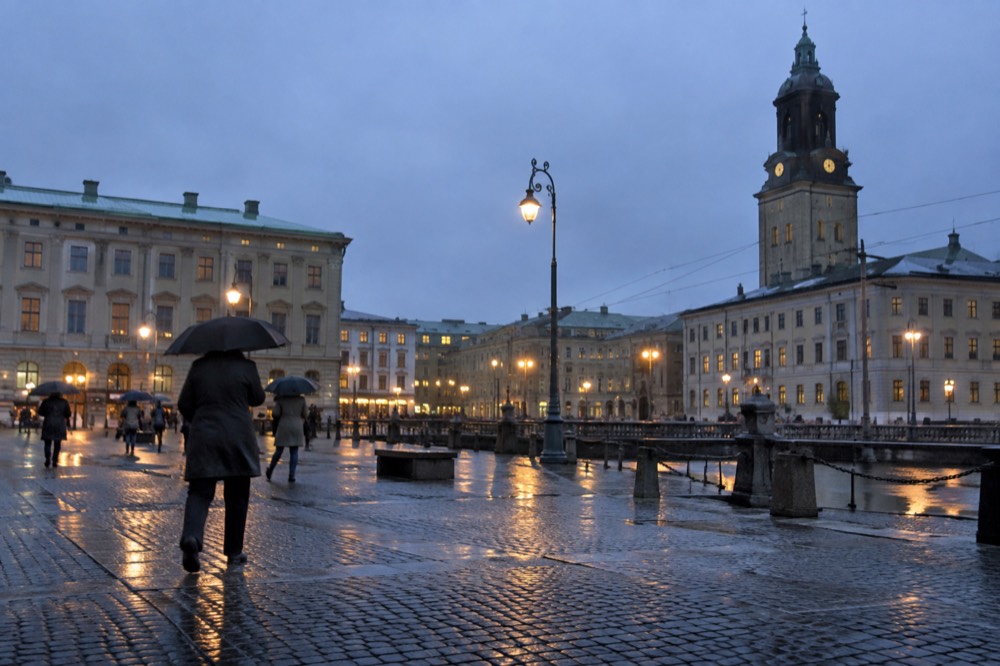 Rainy day visitors with umbrellas crossing a cobblestone square near the museum district