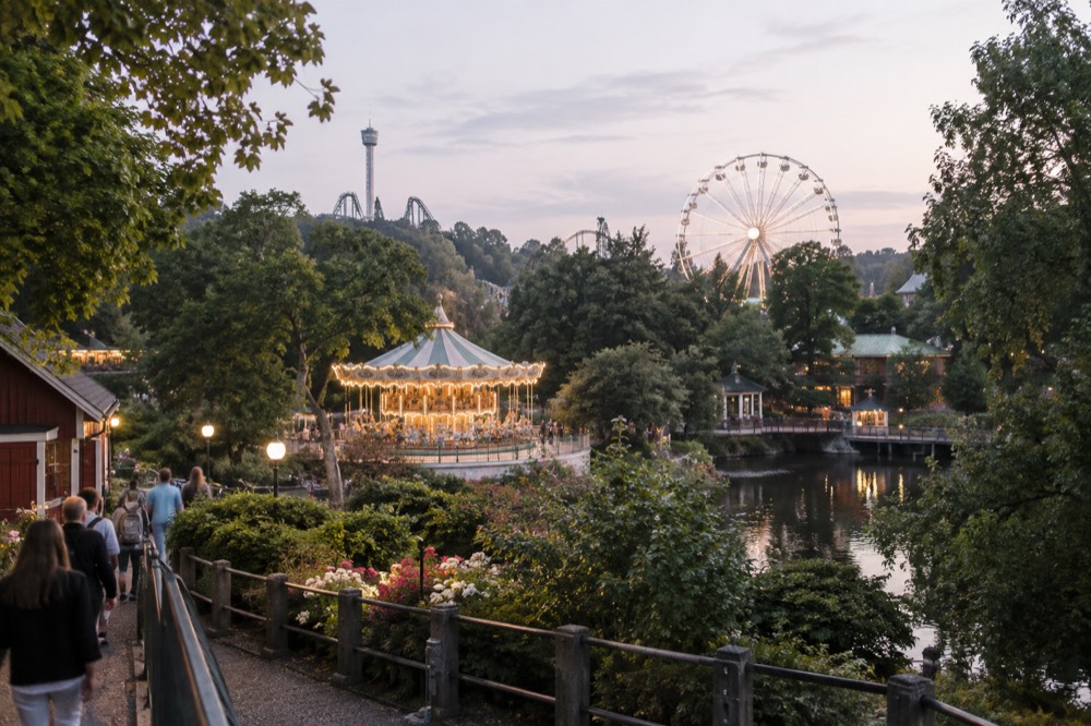 A vintage-style carousel with painted horses lit up at dusk, with fairground lights and a ferris wheel behind it
