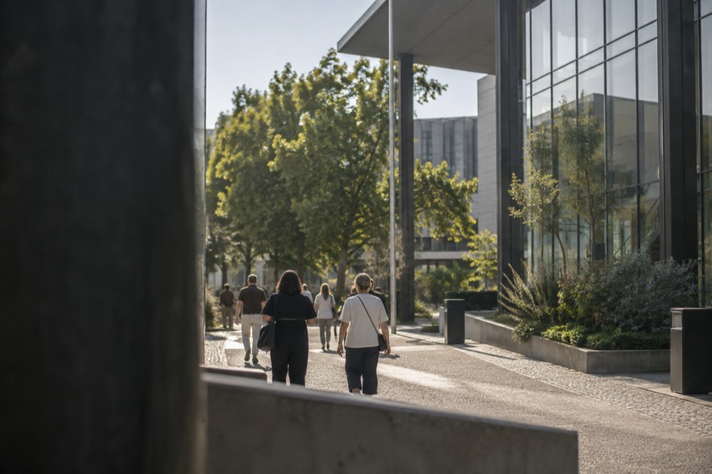 Visitors walking along a tree-lined avenue in central Gothenburg between museum buildings
