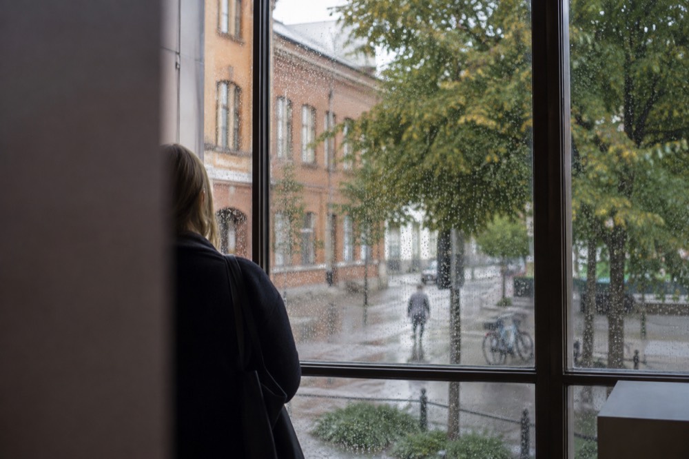 Raindrops on a museum window with a blurred city street visible beyond the glass