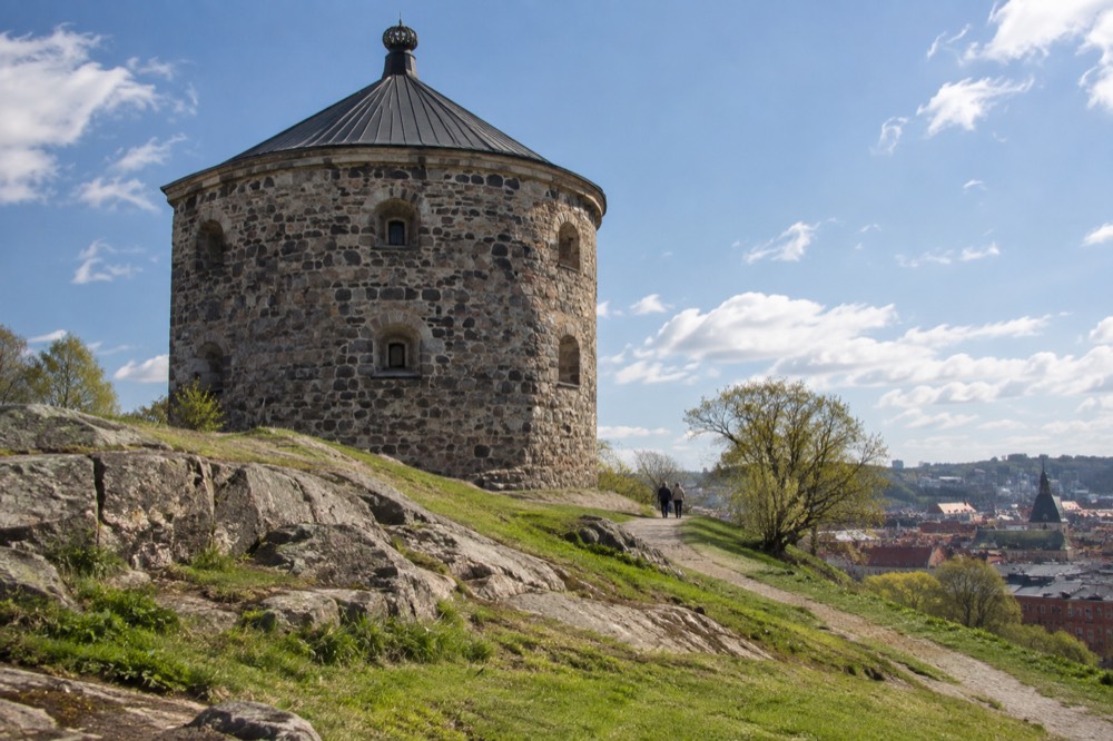 Round stone tower of the fort seen from below against sky