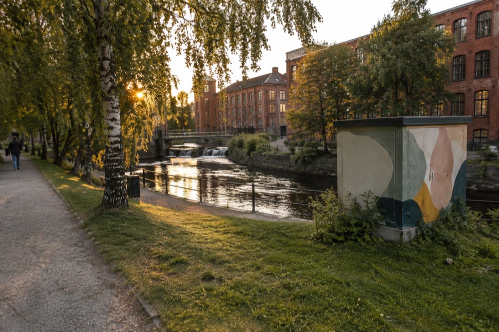 A painted substation and mural wall beside a tram-free street in a small Swedish city