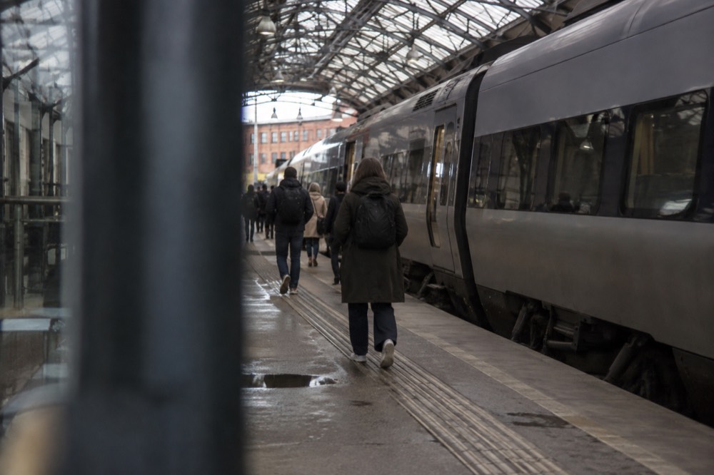 Regional train waiting at a platform inside a Swedish railway station with a glass roof