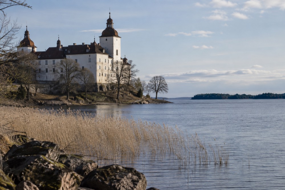 Open lake water stretching to the horizon with wooded islands in the distance under a wide sky