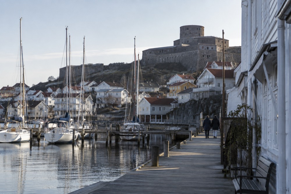 Wooden guesthouses and sailboat masts along a small island street