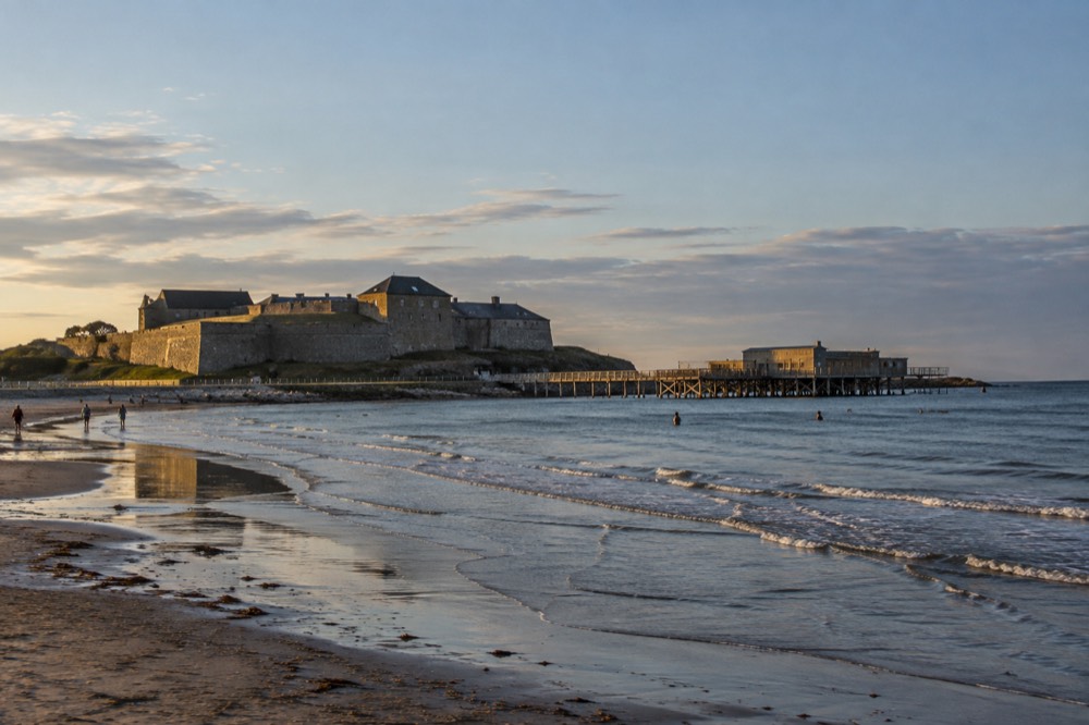 A long sandy beach at Varberg with shallow water and a few swimmers