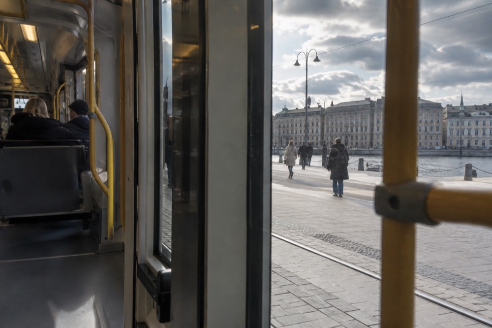 Interior of a modern tram with a wide flat floor and open wheelchair space near the middle doors