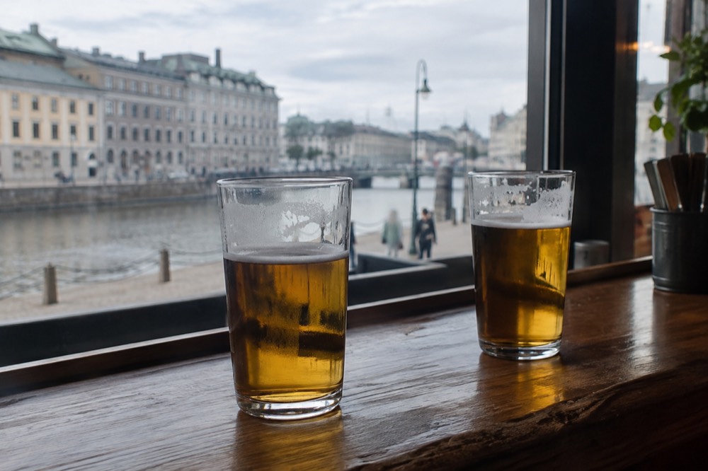 Two beer glasses on a wooden bar counter in a Gothenburg pub