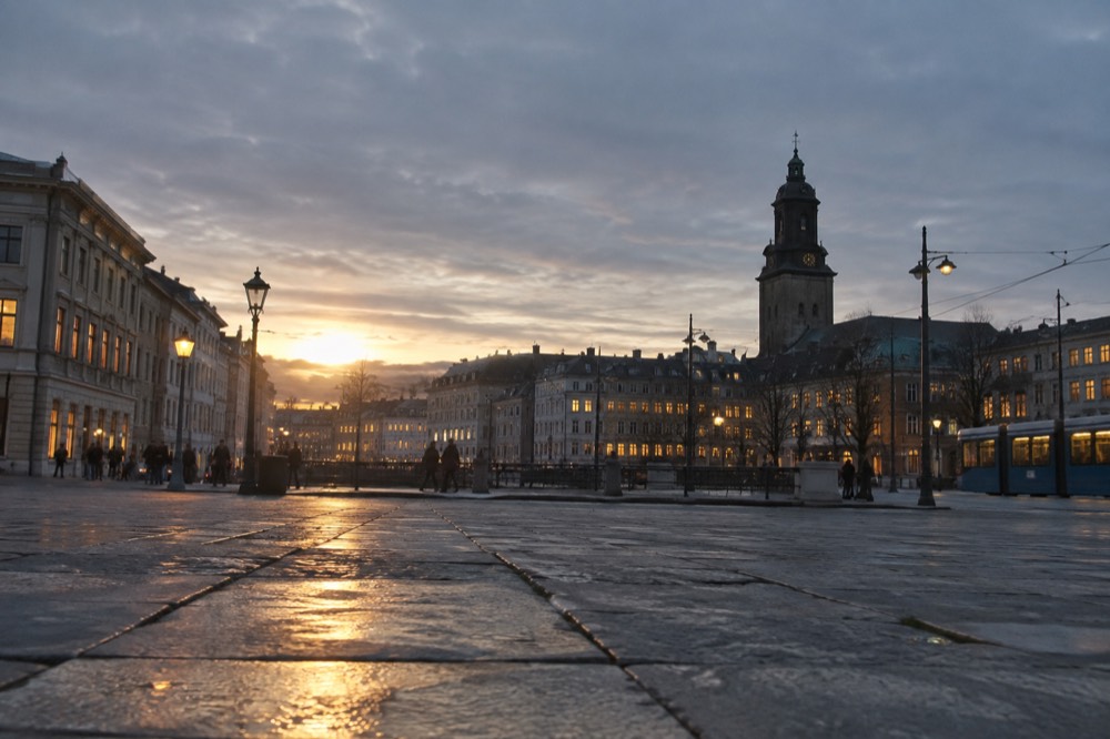 Evening view over Gothenburg rooftops with lit windows and a church tower