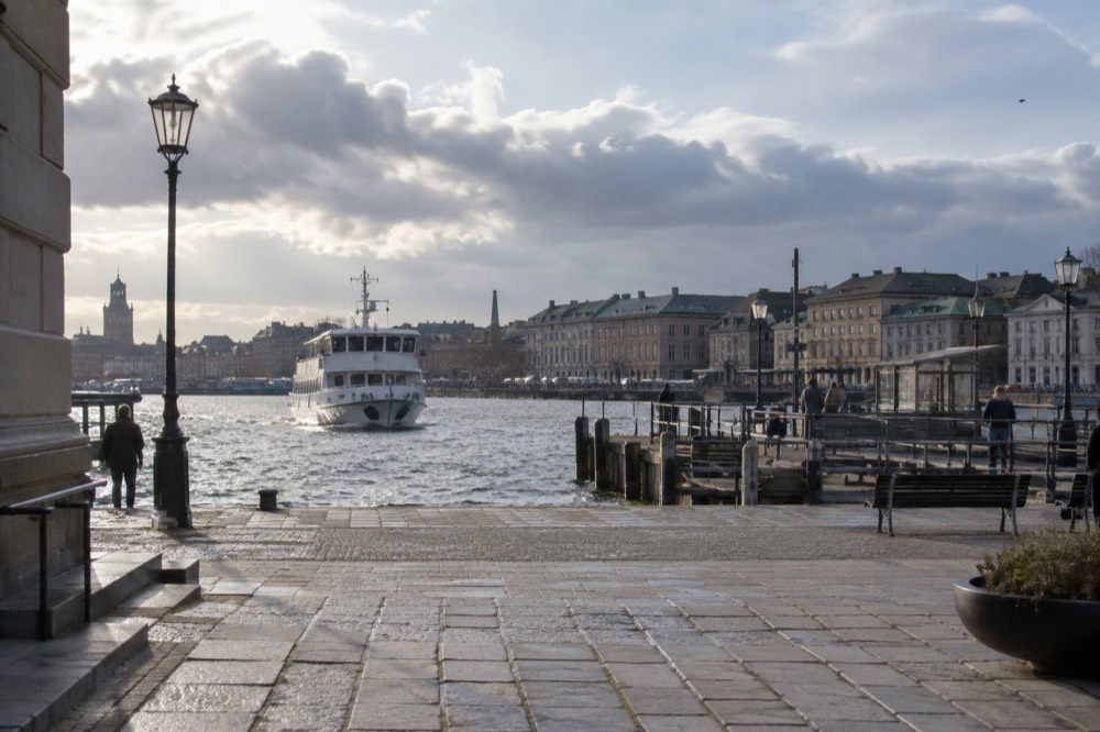 A white archipelago ferry approaching a wooden jetty at a small island quay