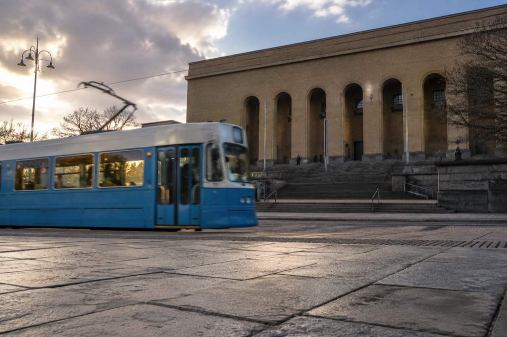 A tram passing the Götaplatsen art museum steps in evening light