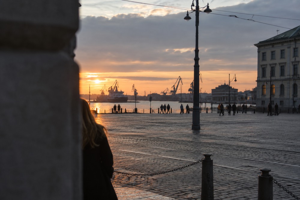Ferry and cranes silhouetted against the Gothenburg river at sunset