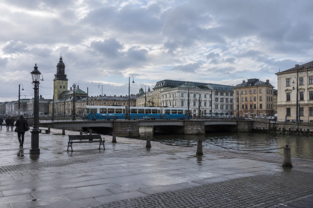 Blue Gothenburg tram crossing a city bridge with passengers aboard