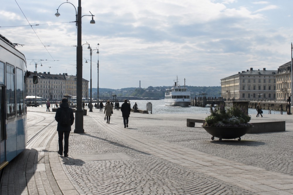 A white ferry approaching a wooden island jetty in the Gothenburg archipelago