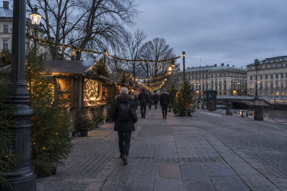 Festive lights strung over a walkway at a Scandinavian Christmas market in the evening