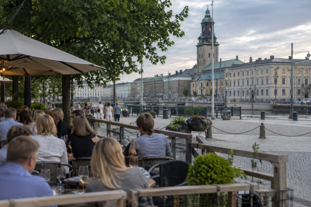 Outdoor restaurant terrace with people eating and drinking on a warm evening in Gothenburg