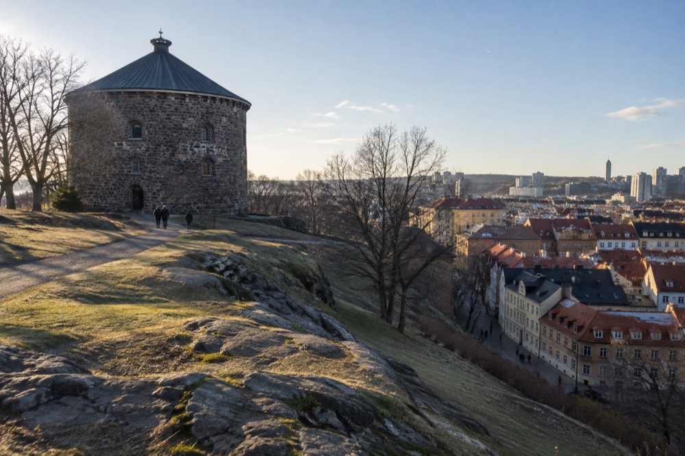 Low golden winter sun over the rooftops of Haga with Skansen Kronan on the hill