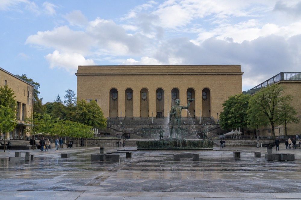 Art museum steps at a plaza with a statue and fountains in front