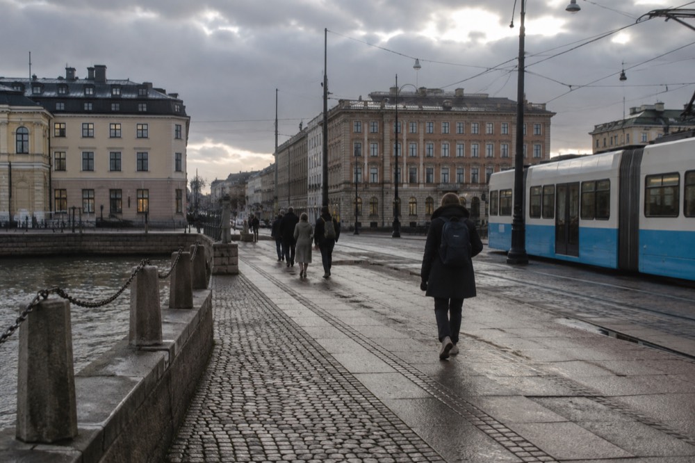 A tram moving along a Gothenburg street with brick buildings on a grey day