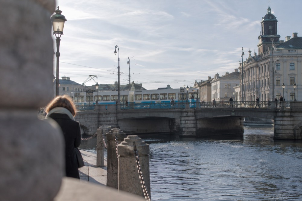 A Gothenburg tram crossing a stone bridge over a city canal