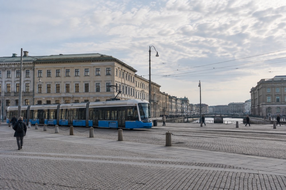 A Gothenburg tram crossing a central square with stone buildings behind