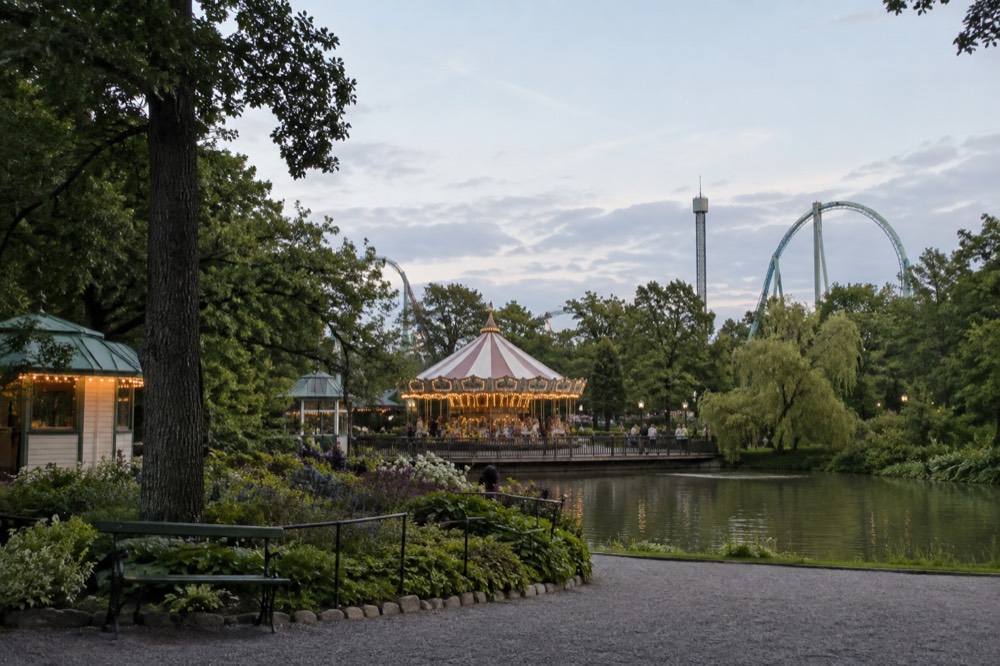 Families riding a carousel at Liseberg amusement park in summer