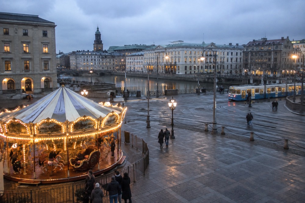 A family riding a vintage carousel at a Scandinavian amusement park at dusk