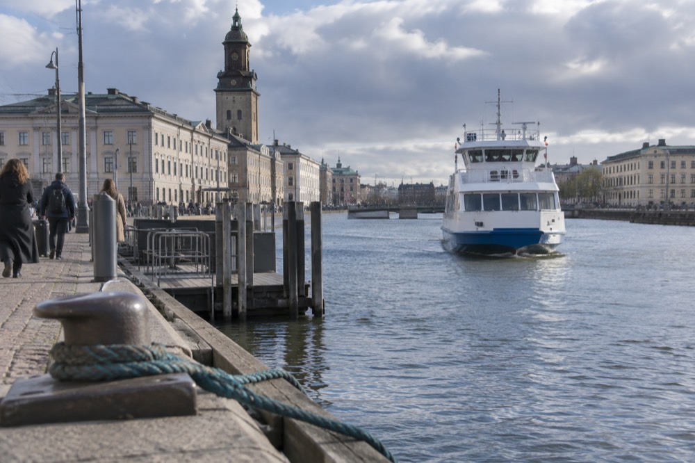 A white ferry approaching a wooden jetty on a car-free Swedish island