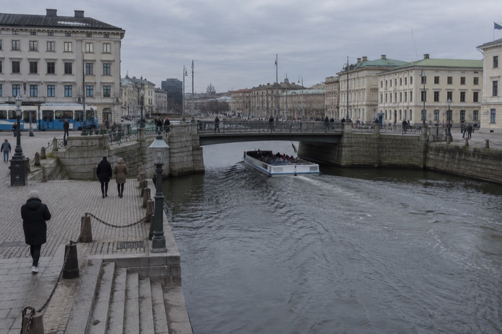A Paddan sightseeing boat passing under a low canal bridge in central Gothenburg