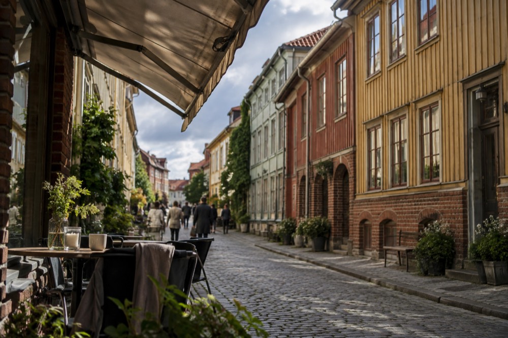 Wooden landshövdingehus facades on a Haga street with a cafe awning