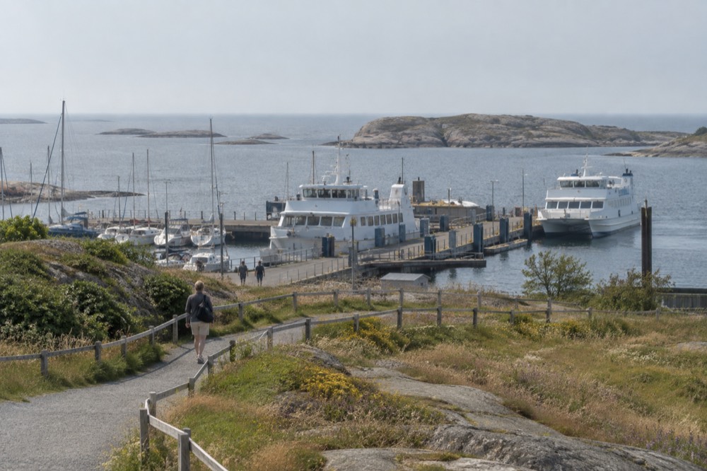 A footpath and wooden fence crossing open meadow on a car-free island in the archipelago