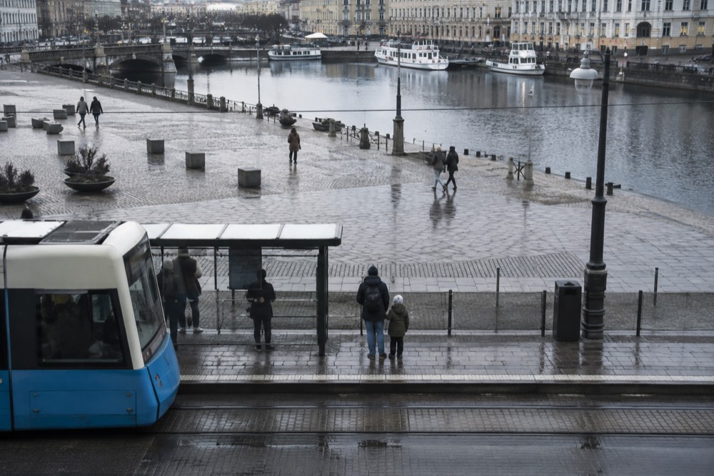 A parent and child waiting at a tram stop in Gothenburg