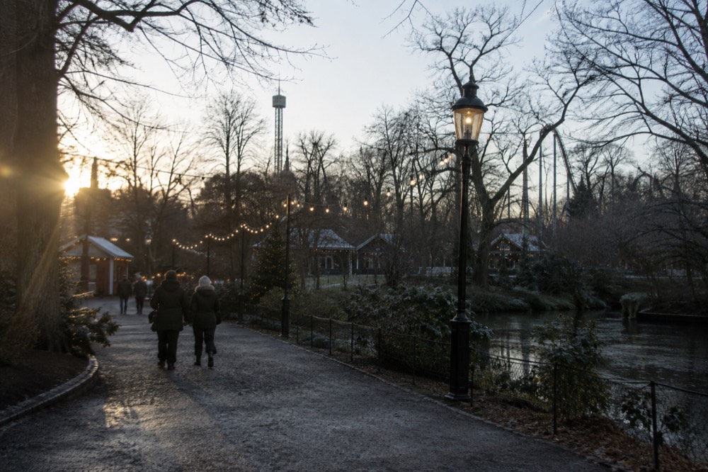 Christmas lights strung over a walkway at Liseberg with market stalls below