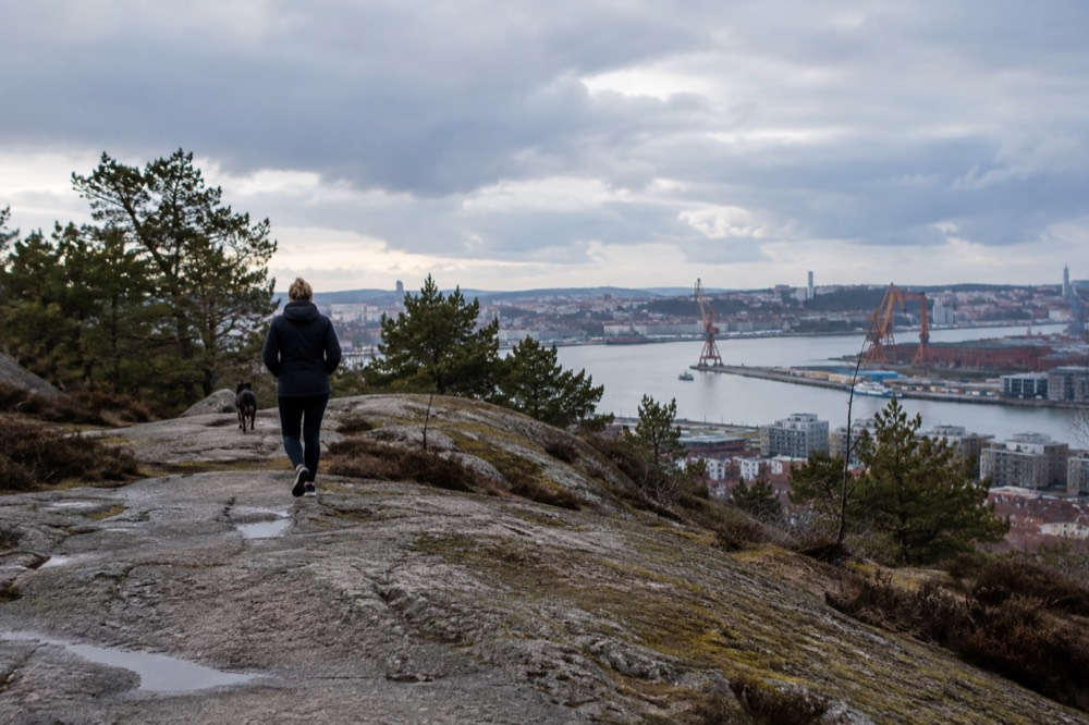 Photographer standing on a granite outcrop at Ramberget with the Gothenburg skyline across the river